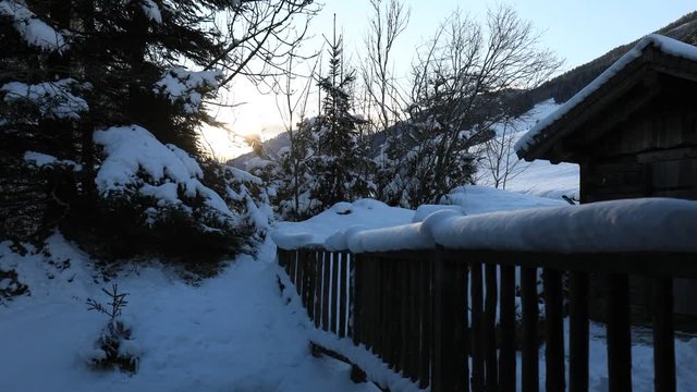 sunrise over snow covered hut and frence in winter time lapse