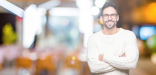 Young handsome man wearing glasses over isolated background happy face smiling with crossed arms looking at the camera. Positive person.