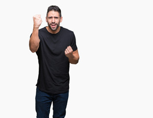 Fototapeta premium Young handsome man over isolated background angry and mad raising fist frustrated and furious while shouting with anger. Rage and aggressive concept.