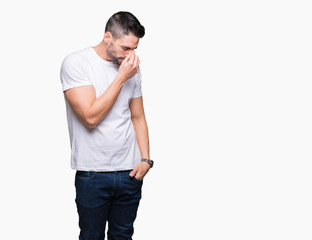 Young man wearing casual white t-shirt over isolated background tired rubbing nose and eyes feeling fatigue and headache. Stress and frustration concept.