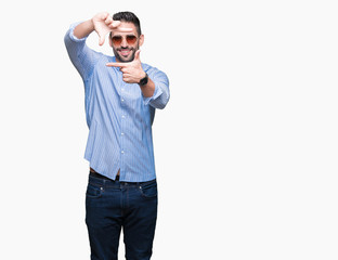 Fototapeta premium Young handsome man wearing sunglasses over isolated background smiling making frame with hands and fingers with happy face. Creativity and photography concept.