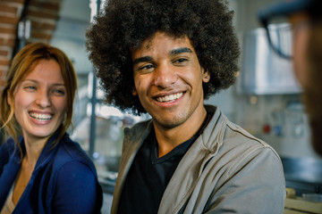 Afro american Man and woman smiling to friend or colleagues at bar.Multiethnic people having break time in restaurant lounge.Corporate,diversity and social concepts.