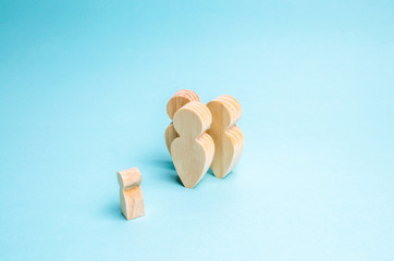 Contact or conversation between a group of people and a child. Wooden figures of people on a blue background. Concept of education, to be an example to follow. Idols. parents and mentors.