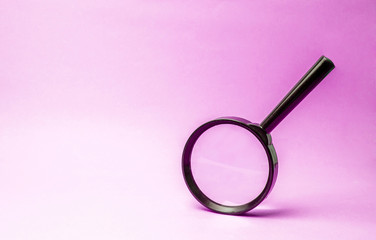 Magnifying glass on pink background. Concept of search and analysis, analytics and study of details. Validation, identification of fakes and crimes, review and study of the world.