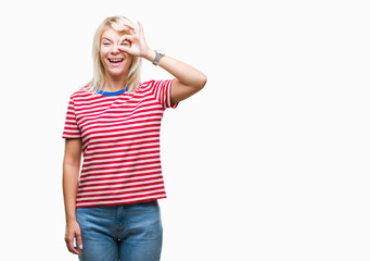 Fototapeta premium Young beautiful blonde woman over isolated background doing ok gesture with hand smiling, eye looking through fingers with happy face.