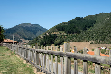 Fototapeta na wymiar wooden fence in a meadow with the mountains of asturias in the background on a sunny day