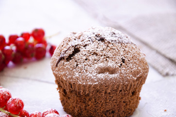 Fototapeta na wymiar chocolate cupcake with cream, powdered sugar and berries
