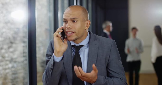 4K Annoyed businessman on a phone call, reacting to news of a business problem