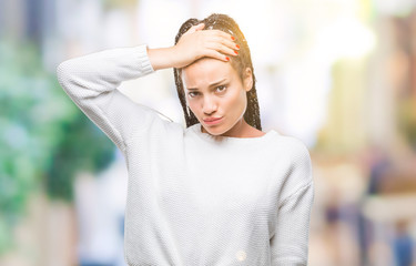 Young braided hair african american girl wearing winter sweater over isolated background confuse and wonder about question. Uncertain with doubt, thinking with hand on head. Pensive concept.