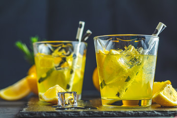 Lemon alcohol drink cocktail with ice, lemon and rosemary