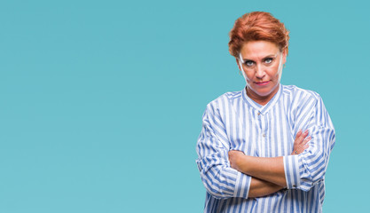 Atrractive senior caucasian redhead woman over isolated background skeptic and nervous, disapproving expression on face with crossed arms. Negative person.