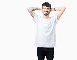 Young handsome man wearing white t-shirt over isolated background Relaxing and stretching with arms and hands behind head and neck, smiling happy