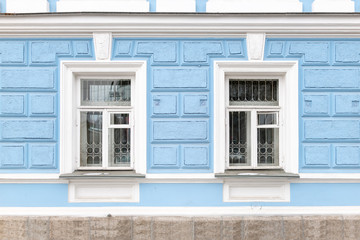 Fototapeta na wymiar Two windows of an old 19th century mansion with blue walls