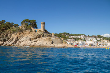 Fototapeta na wymiar Sea view of the tower of the castle of the medieval village of Tossa de Mar, one of the most picturesque and touristic places of the Catalan Costa Brava