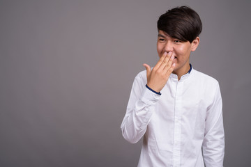 Fototapeta premium Young Asian teenage boy against gray background