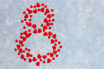 Red hearts figurines in the form of eight on light background. Concept for Women's Day March 8