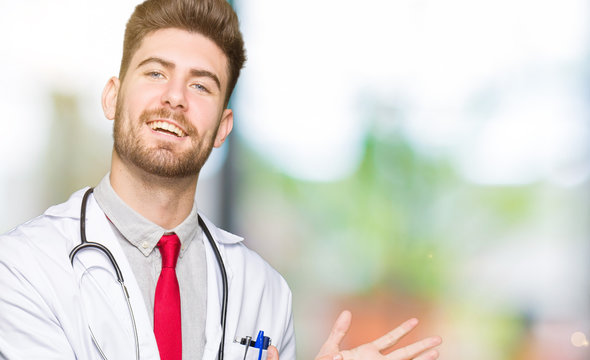 Young handsome doctor man wearing medical coat Clapping and applauding happy and joyful, smiling proud hands together