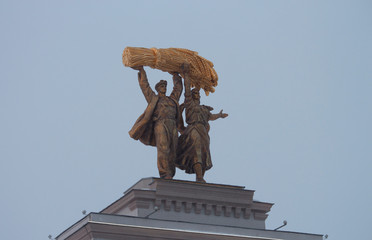 statues man and woman on a building in the park Exhibition of Achievements of National Economy