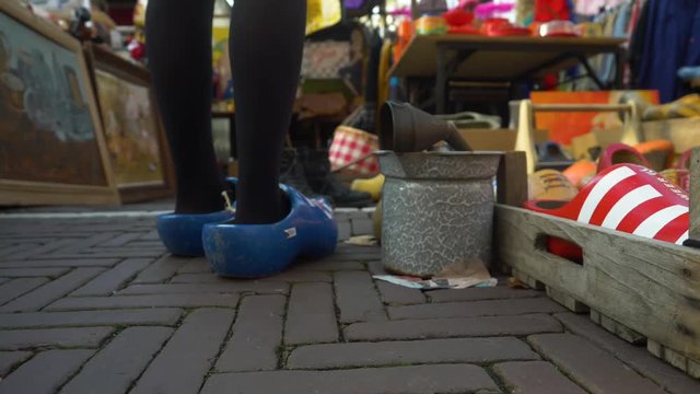 A girl's feet wearing "klompen" or clogs, wooden footwear from Amsterdam, in the colours of the flag of Friesland at a second hand market in the Netherlands