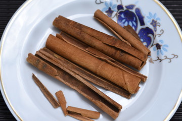 allspice, cinnamon stick, and apricot kernel on a porcelain plate