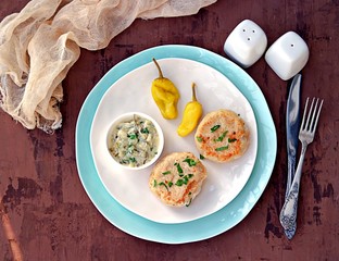 Homemade fish cakes on a white plate. Served with tartar sauce and marinated hot pepper.