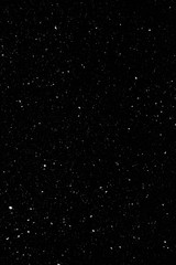 Real snow falling in a winter night. White snow on black background. Abstract elements to use in...