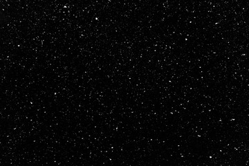 Real snow falling in a winter night. White snow on black background. Abstract elements to use in graphic design or as an overlay for other photos.