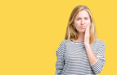 Beautiful young woman wearing stripes sweater over isolated background touching mouth with hand with painful expression because of toothache or dental illness on teeth. Dentist concept.