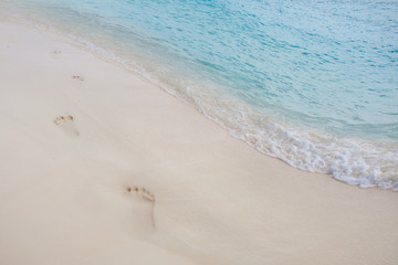 Footprints in the sand. Paradise tropical island, white sand and clear water. 