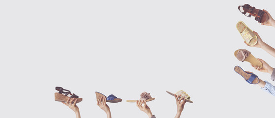 Hands holding different slippers on isolated background