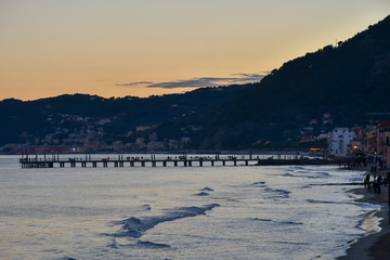 Scenic view of the beach and the pier of Alassio at sunset