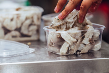 Female Chef Putting Fresh Shrimps into Plastic Container - Kitchen Set