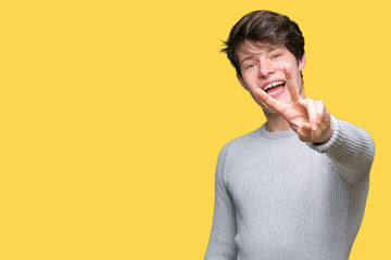 Young handsome man wearing winter sweater over isolated background smiling looking to the camera...