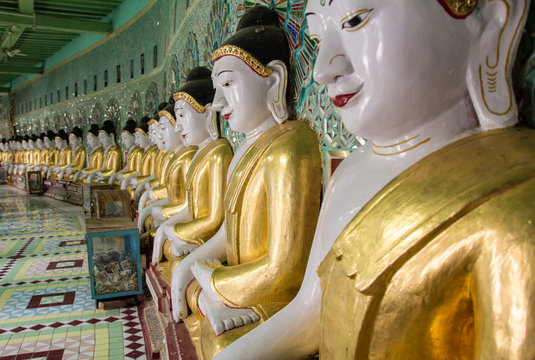 Ancient set of golden Buddha statues in a row in Myanmar