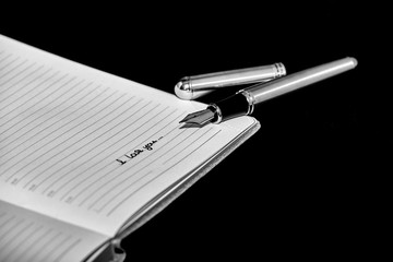 Fountain pen next to a notepad with the inscription