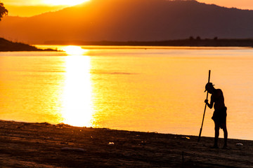 Farmer during a sunset at the coast of Irrawaddy (Ayeyarwady) river in Bagan, Myanmar