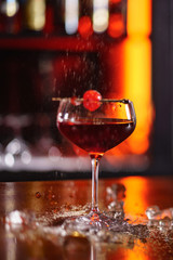 cocktail in the bar with orange zest and cherry