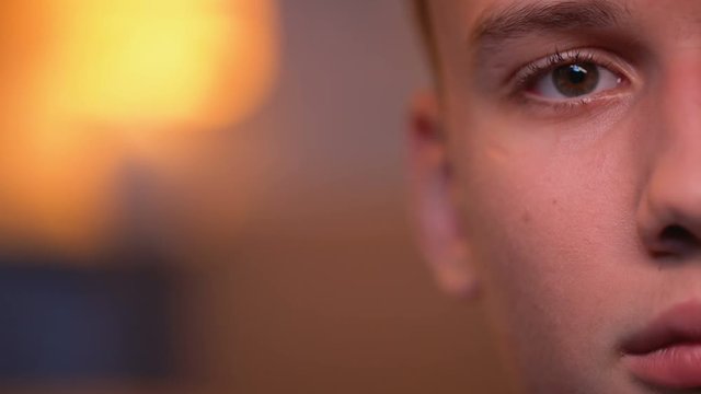 Handsome teenage boy looking directly to camera, background, half-face close-up
