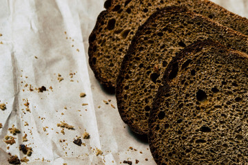 Sliced black bread on a dark background