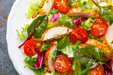 Fresh vegetable salad with grilled chicken meat, top view