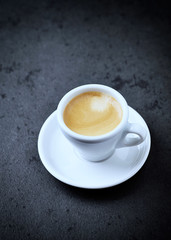 Cup of coffee on black stone background. Copy space.
