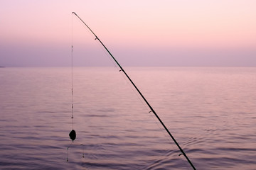 fishing rod with a tackle on the lake in the morning
