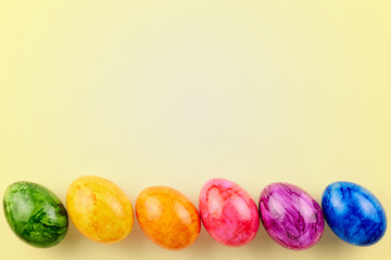 Colored Easter eggs on yellow background.