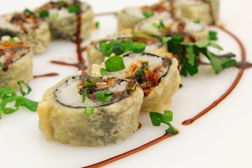 Hot fried Sushi Roll with salmon skin, chive and teriyaki. Sushi menu. Japanese food. Futomaki. Isolated on white background