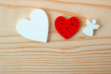 two hearts and angel on wooden background