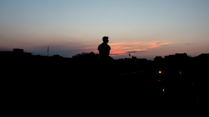 silhouette of man on top of ledge
