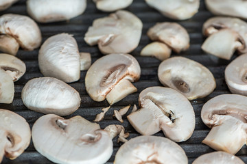 Sliced champignons mushrooms grilled on electric grill or BBQ close up view