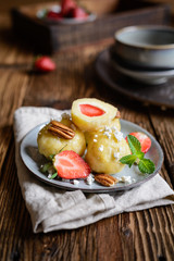 Sweet dumplings stuffed with strawberries topped with curd