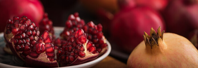 Cuted fresh pomegranate fruits on rustic background. banner maket. selective focus