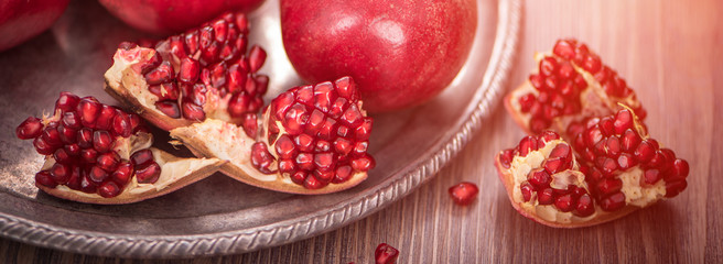 Cuted fresh pomegranate fruits on wooden rustic background. banner maket. selective focus